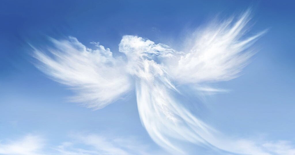 Angel in the clouds on blue sky