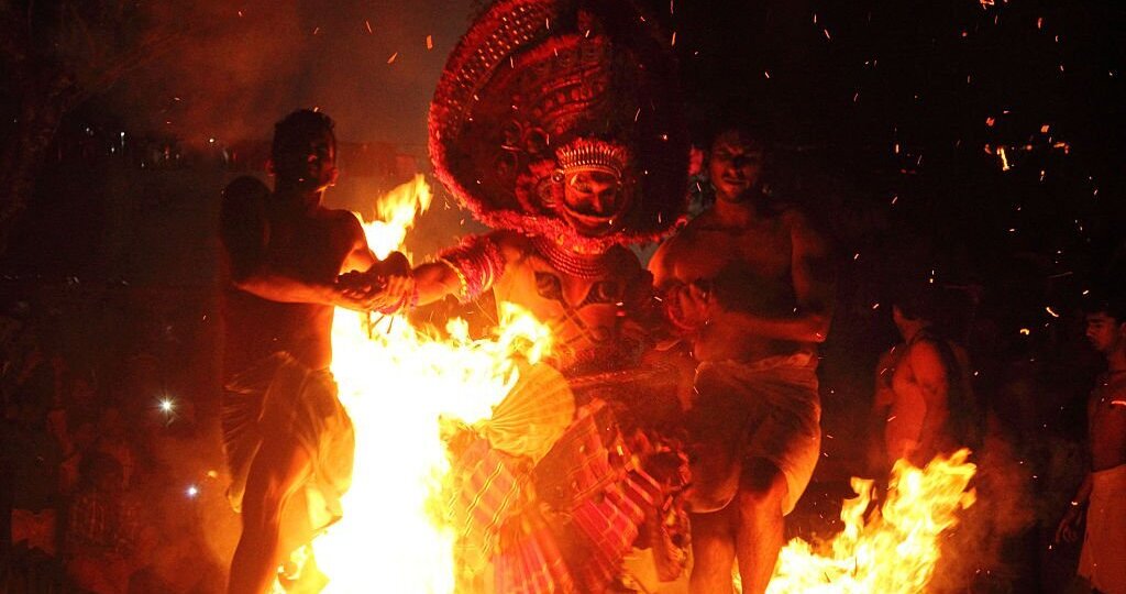 An unidentified Theyyam artist performs a fire walk ritual in the early morning 
