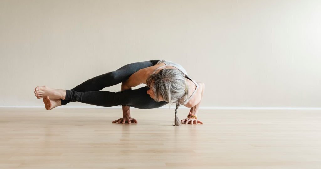 Fit yogi woman doing Eight-angle pose