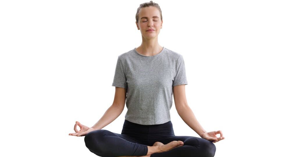 Young attractive woman sitting in Ardha Padmasana exercise