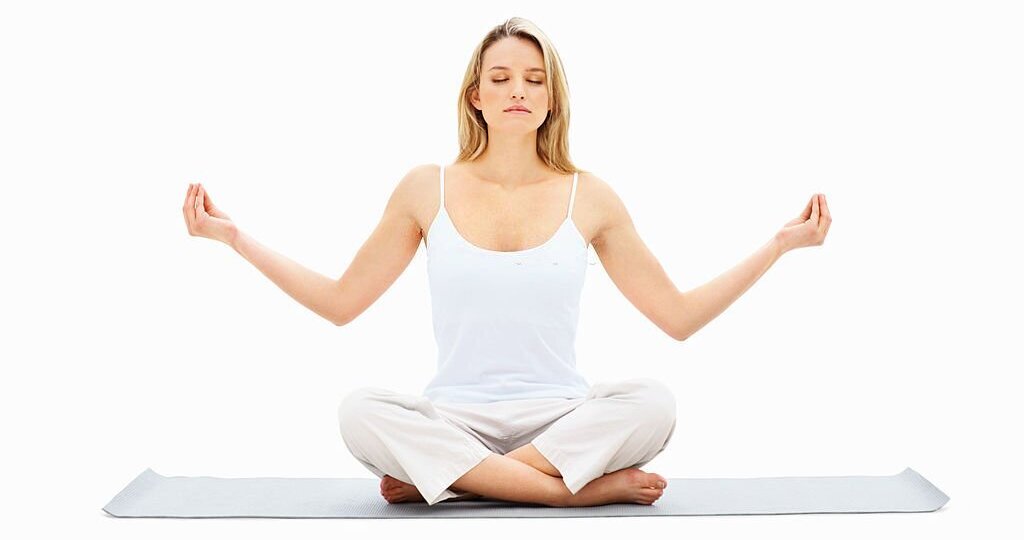 Woman practicing yoga on white yoga mat