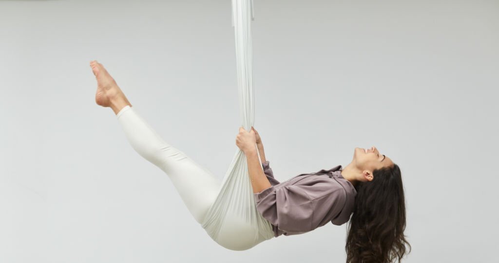 One woman practicing aerial yoga