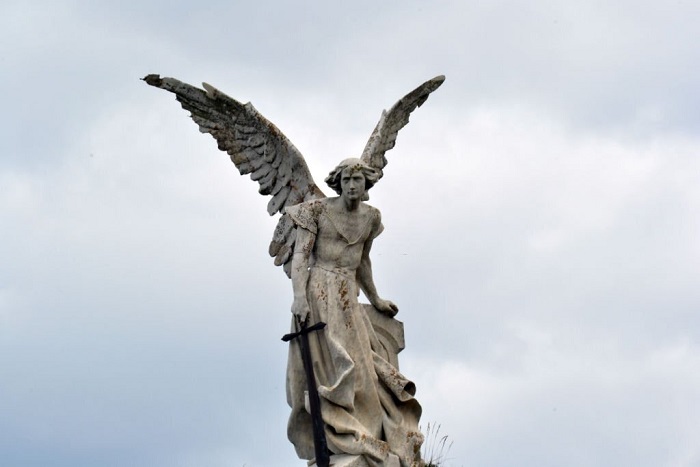 Frontal view of a statue of the archangel San Miguel in a cemetery
