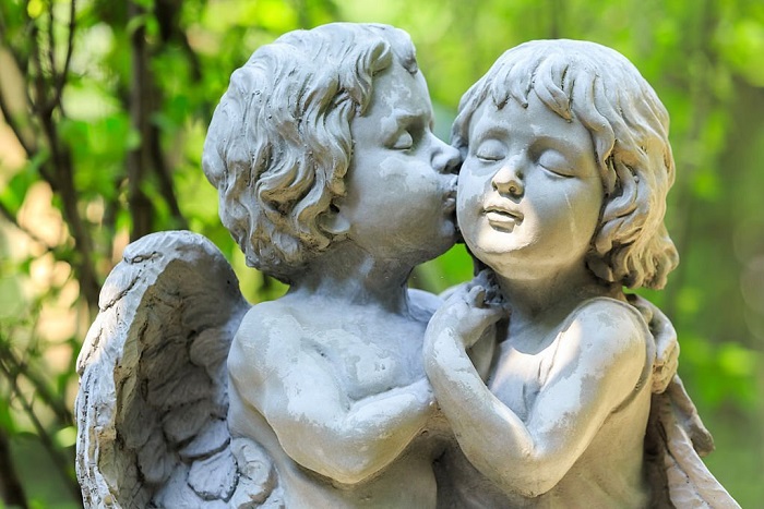 Little couple angel sculpture in green garden