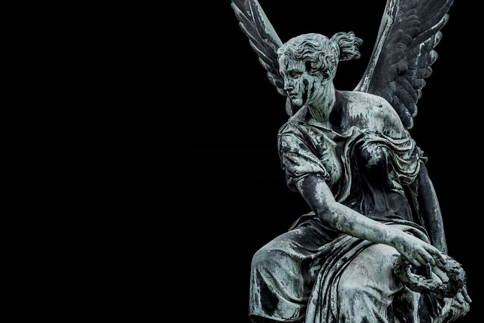 Statue of ancient beautiful winged angel in downtown of Potsdam, isolated at black background, Germany