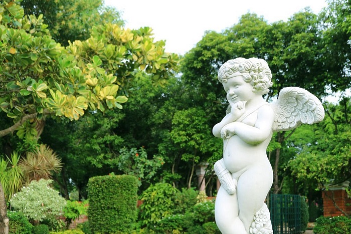  Adorable naughty cupid sculpture in the summer garden