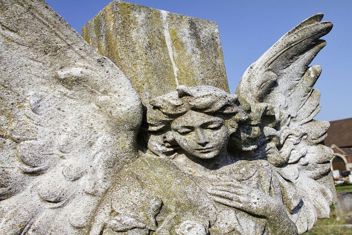 Source: Istockphoto. This winged and weathered angel, carrying roses and placed on a cross