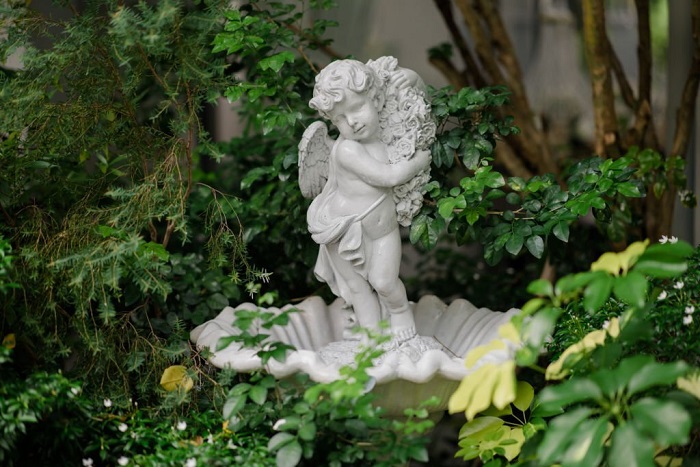 Cute baby corner antique stone doll statue, close-up of newly built home garden stone statue