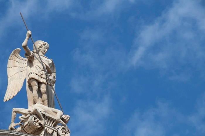 Stone statue of St Michael killing the Satan , on the top of St Jacobs cathedral