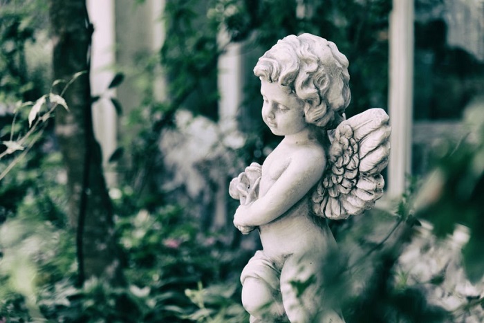 Beauty Cupid statue of Angel in vintage garden on summer
