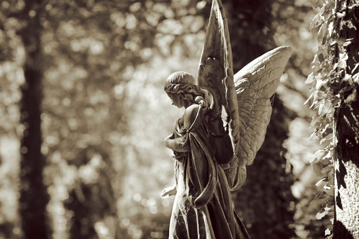 Weathered old angel statue on a cemetery