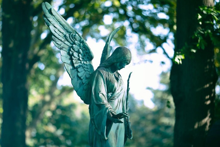 Weathered old copper angel statue on a cemetery in Germany