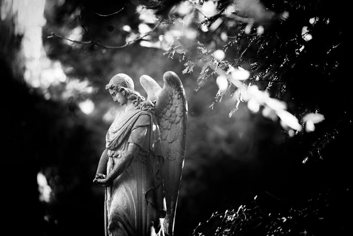 Weathered old stone angel statue at Graveyard