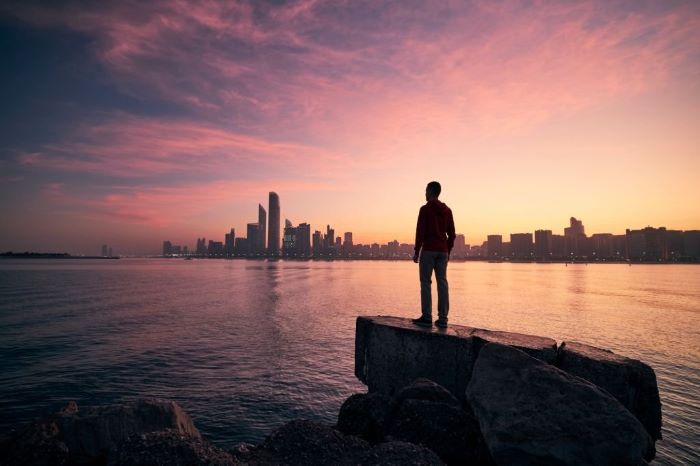 Anthony looking on cityscape at colorful dawn