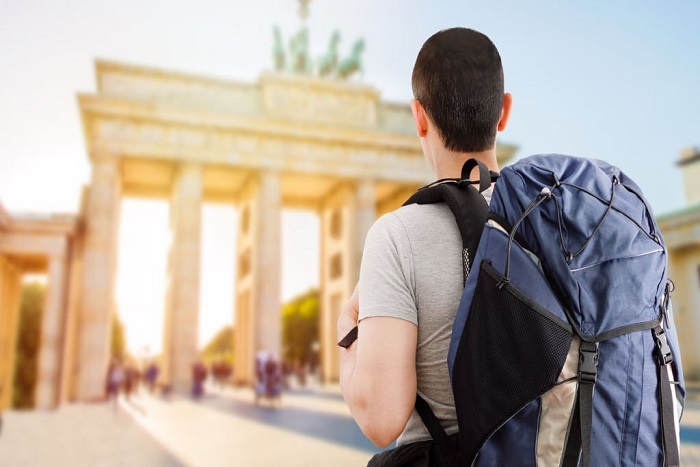 Christopher in Europe and looking at the Brandenburg gate in Germany with backpack and back