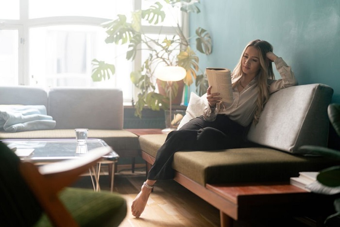 Eliza reading a book at home in her living room