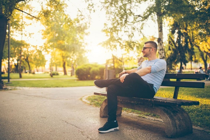 Jeremy sitting in a park on a bench, on a sunny april day. 