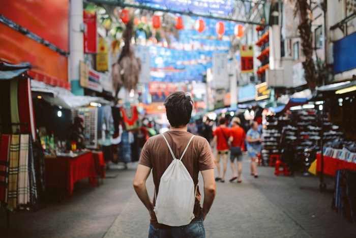 Rear view image of a Lincoln, solo traveler, walking in the Chinatown district of Kuala Lumpur, Malaysia