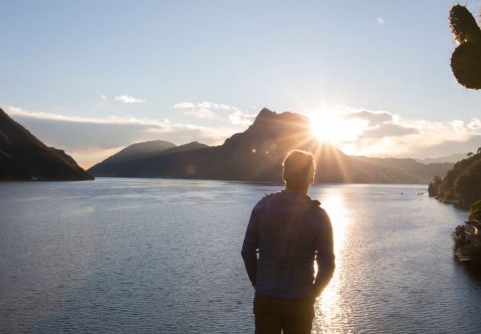 Logan past man to lake, sun and mountains