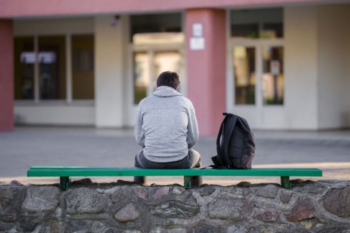 Max sitting on bench at school yard. Break time. 