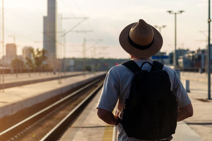 Owen wearing straw hat standing on the railway platform and waiting train