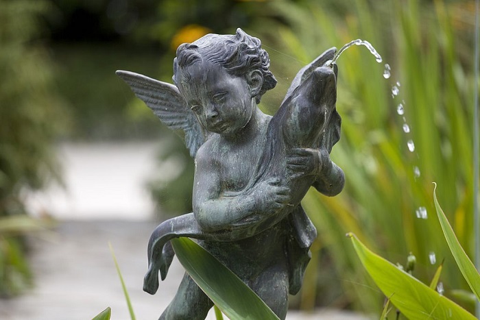  Cherub Fountain, Bronze winged Cherub with a fish Fountain on a plinth with plants