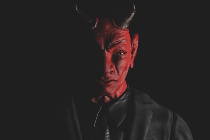 Appearance of red devil from the darkness. Light from the side