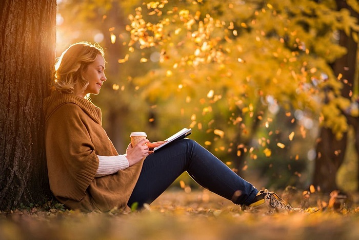 Elise sitting in the park and reading a novel