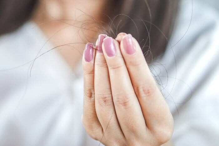 Woman hand holding hair fall from hairbrush