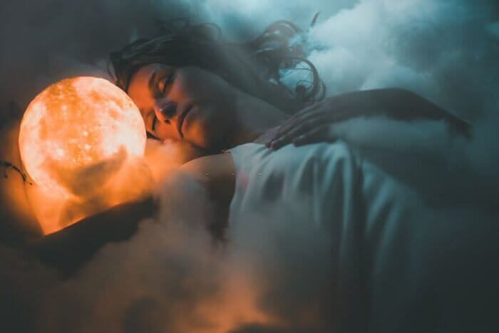 Woman sleeping on cloud and dreaming