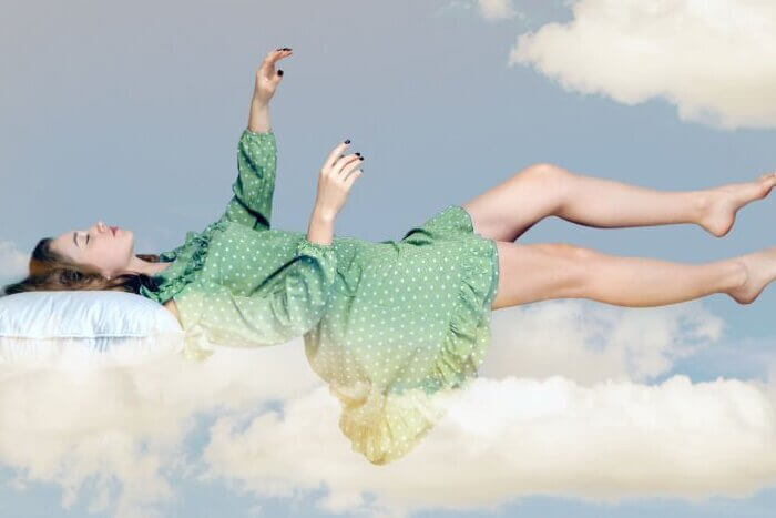 Young relax woman in dress sleeping on pillow in the sky