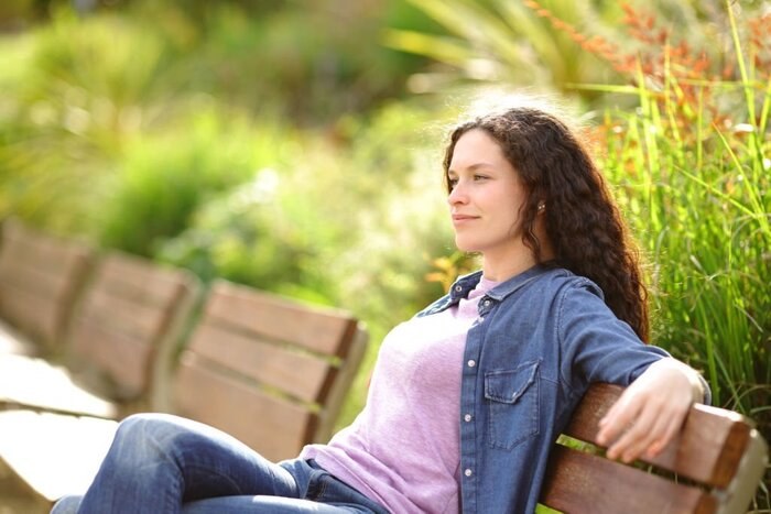 Woman Contemplating from Bench in a Park 